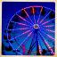 The ferris wheel lit up against the evening sky.